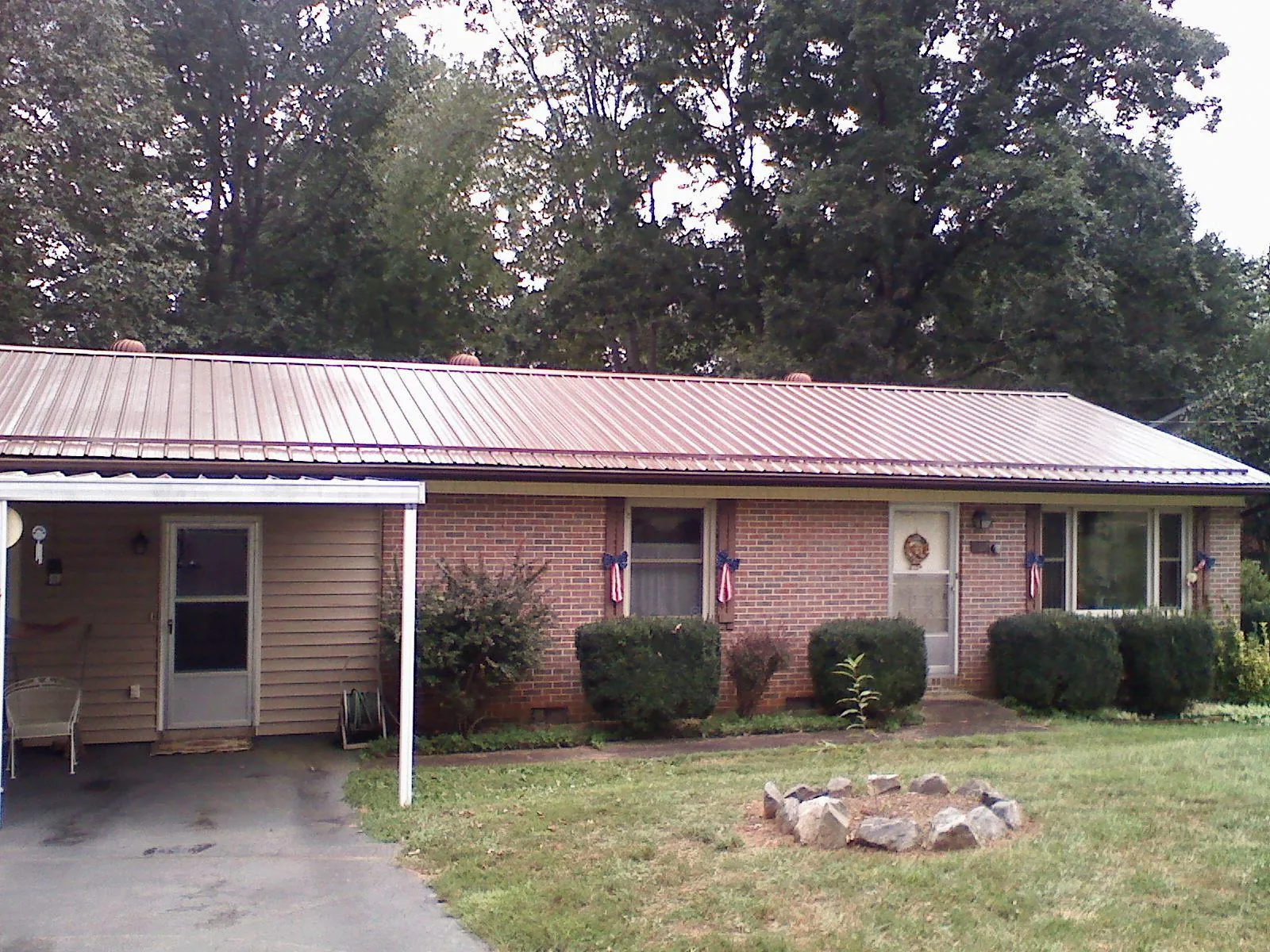 Bronze metal roof and carport on a brick ranch home — Roof Repair work by our crew in Houma