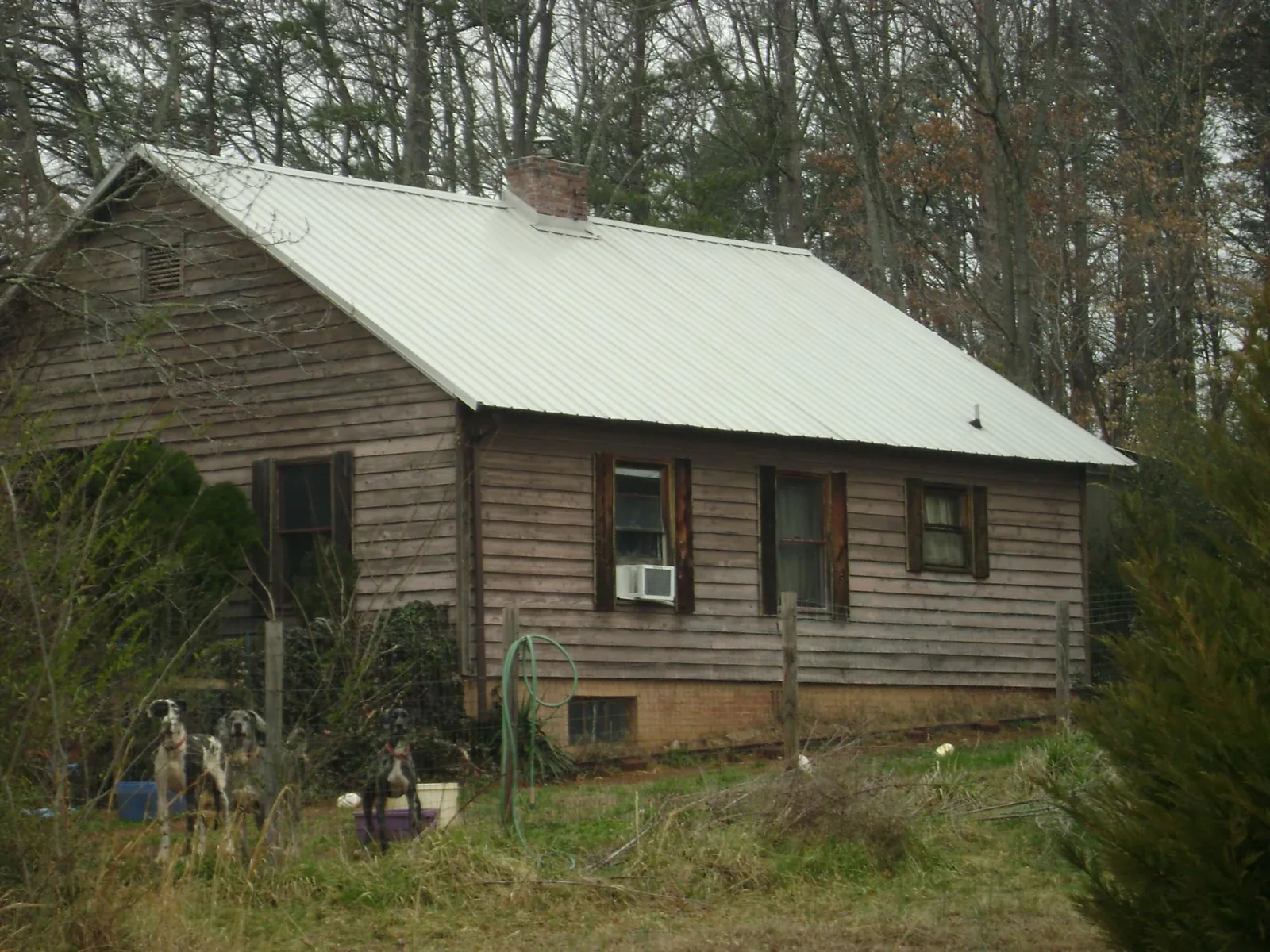 White metal roof on an old wood sided farmhouse, from a Metal Roof Installation job in Houma